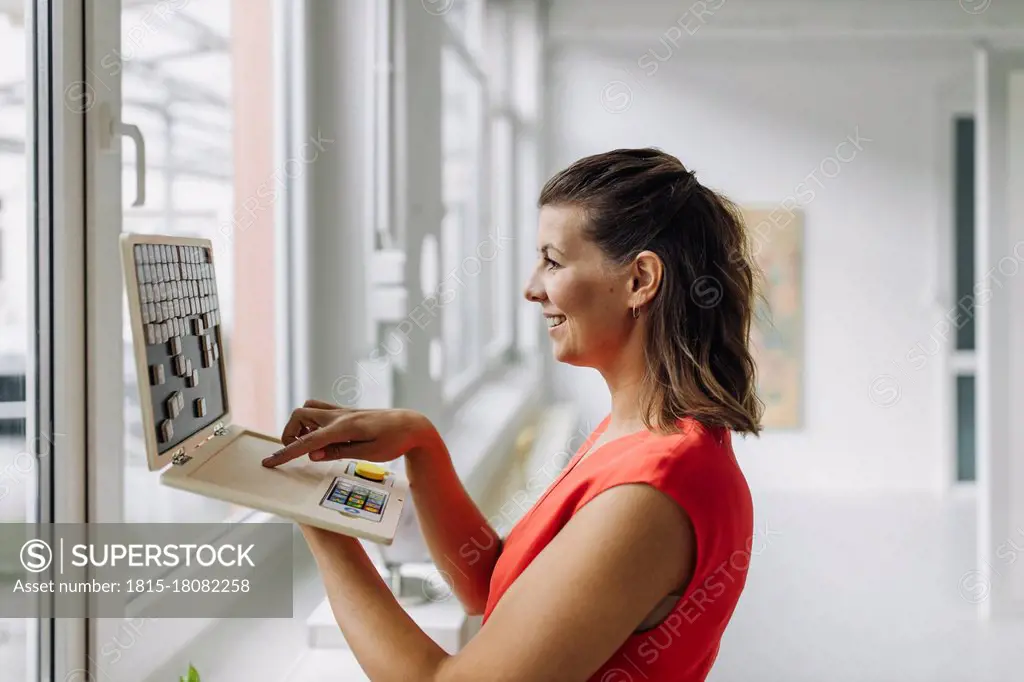 Smiling businesswoman with laptop in office