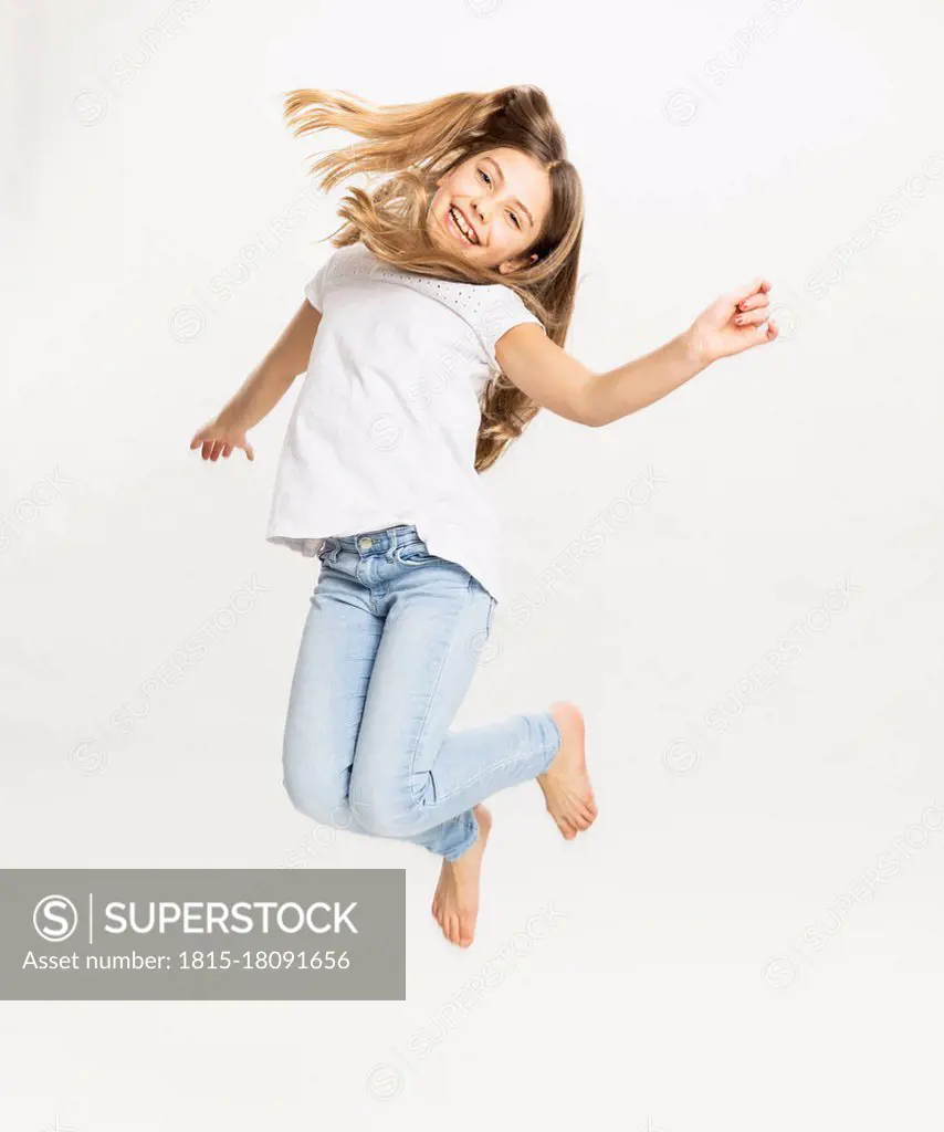 Smiling girl jumping against white background