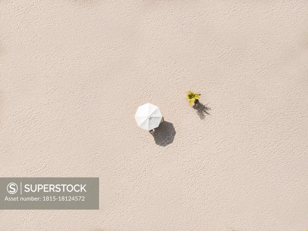 Aerial view of single beach umbrella on sandy beach