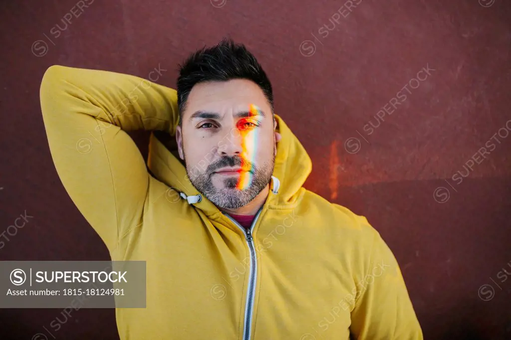Handsome man with spectrum on face while lying on sports court