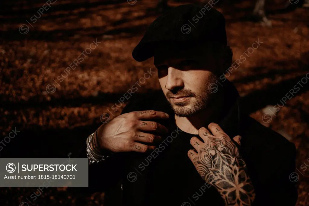 Hipster man with beret in forest during autumn