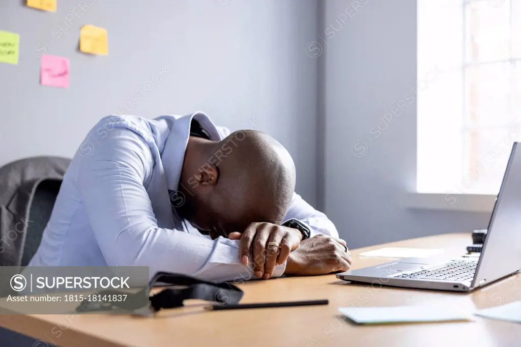 Businessman resting while sitting at desk in office