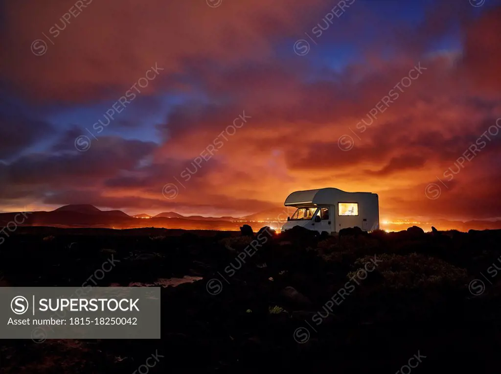 Spain, Canary Islands, Motor home parked along rocky coast of Lanzarote island at sunset