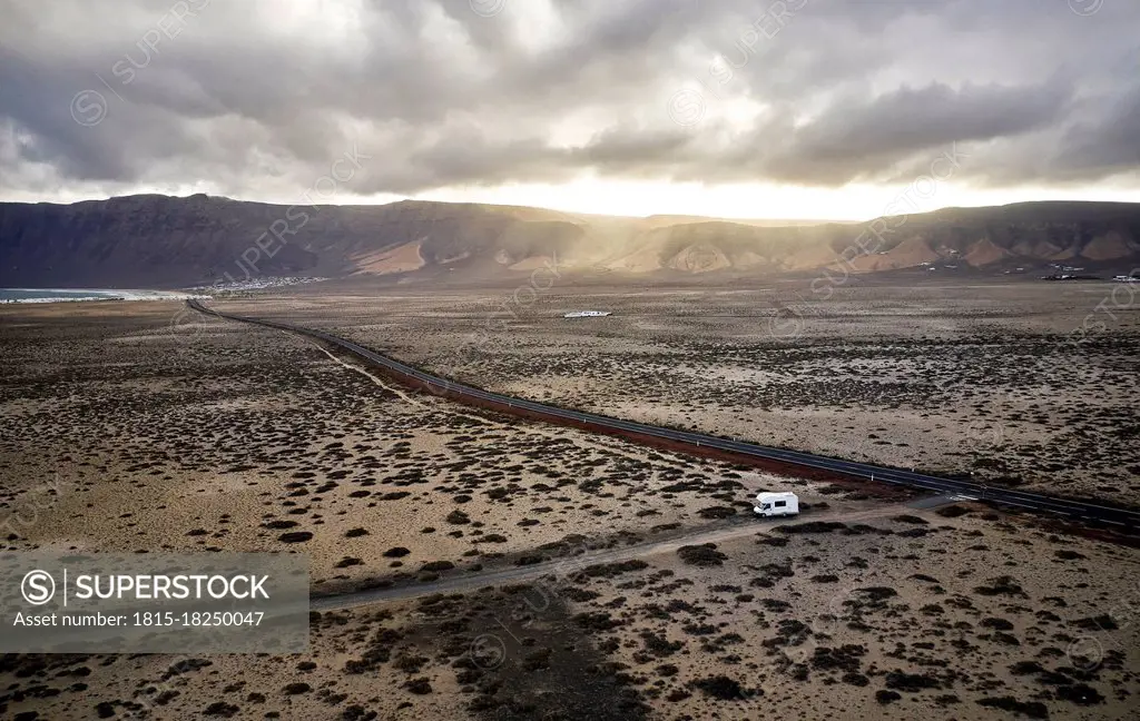 Spain, Canary Islands, Aerial view of motor home driving along gravel road at Lanzarote island