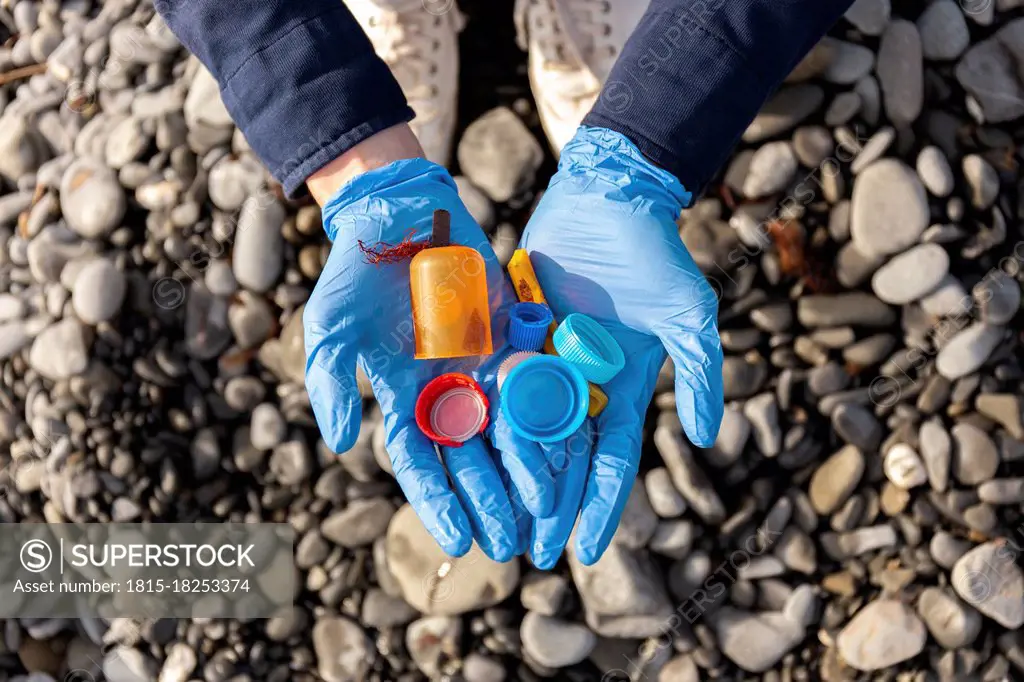 Woman in protective glove holding plastic cap