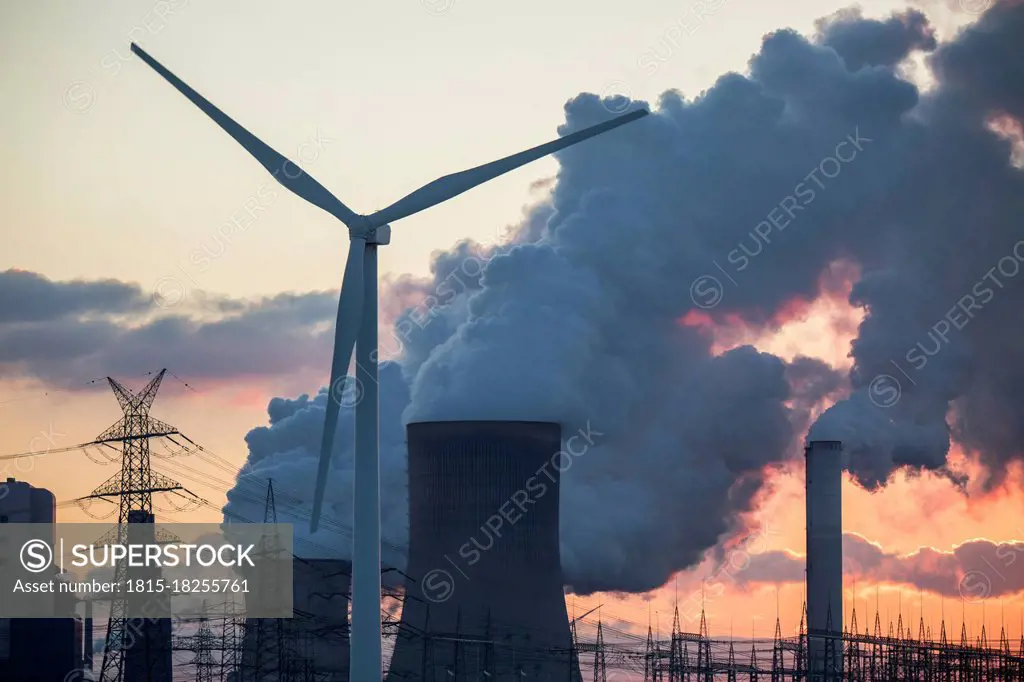 Germany, North Rhine Westphalia, Niederaussem, Wind turbines and lignite power station at sunset