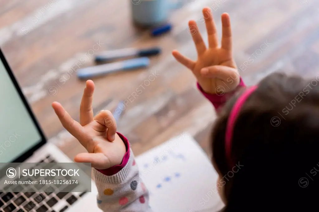 Girl counting fingers while studying at home