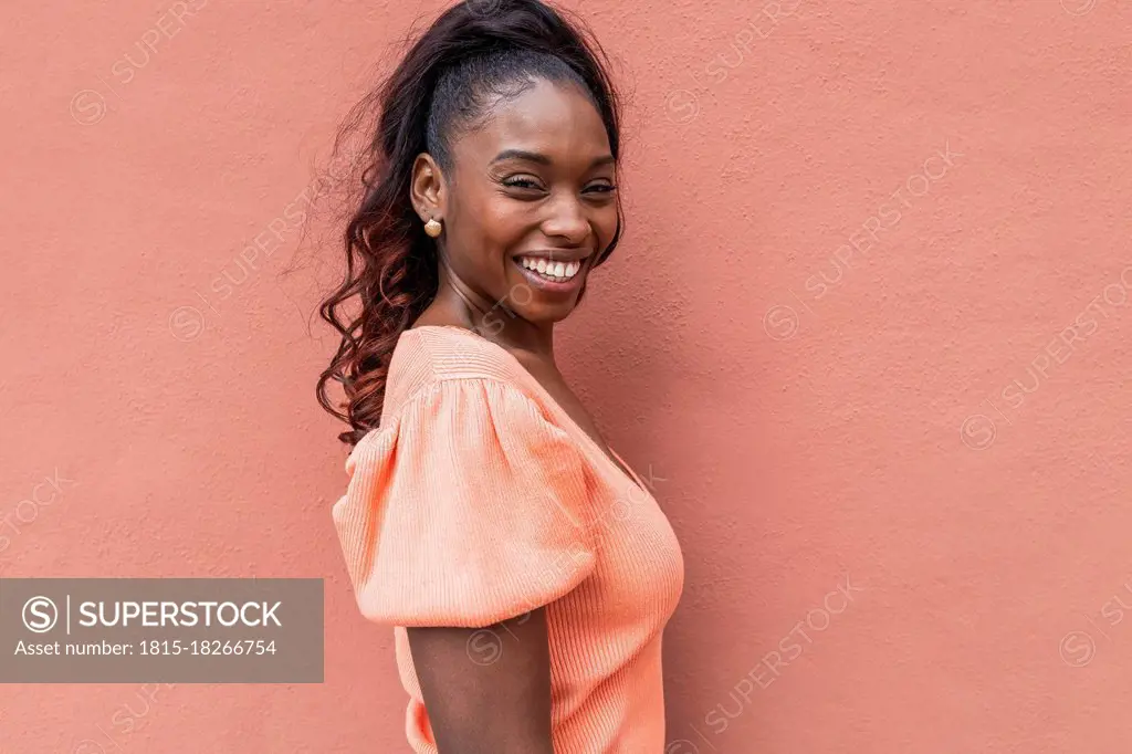 Smiling mid adult woman by wall