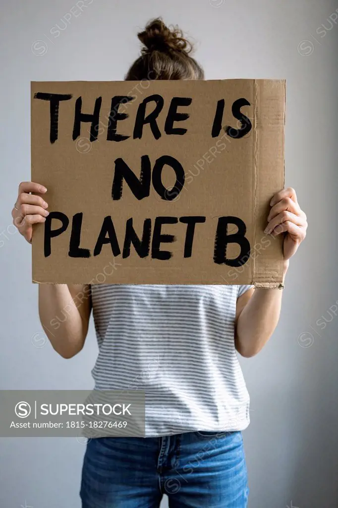 Woman holding environment protection message cardboard in front of studio