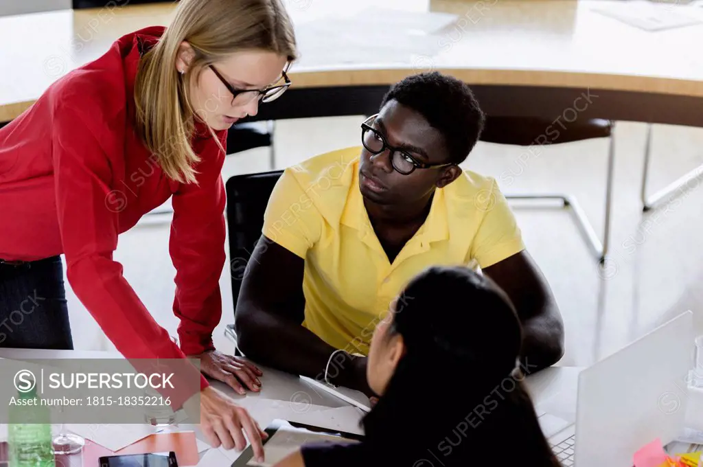 Caucasian businesswoman explaining business plan to male and female colleagues in office