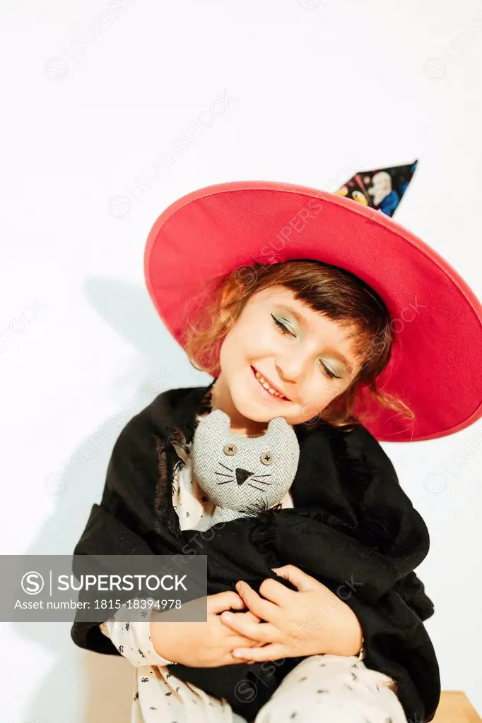 Girl with Halloween costume holding stuffed toy
