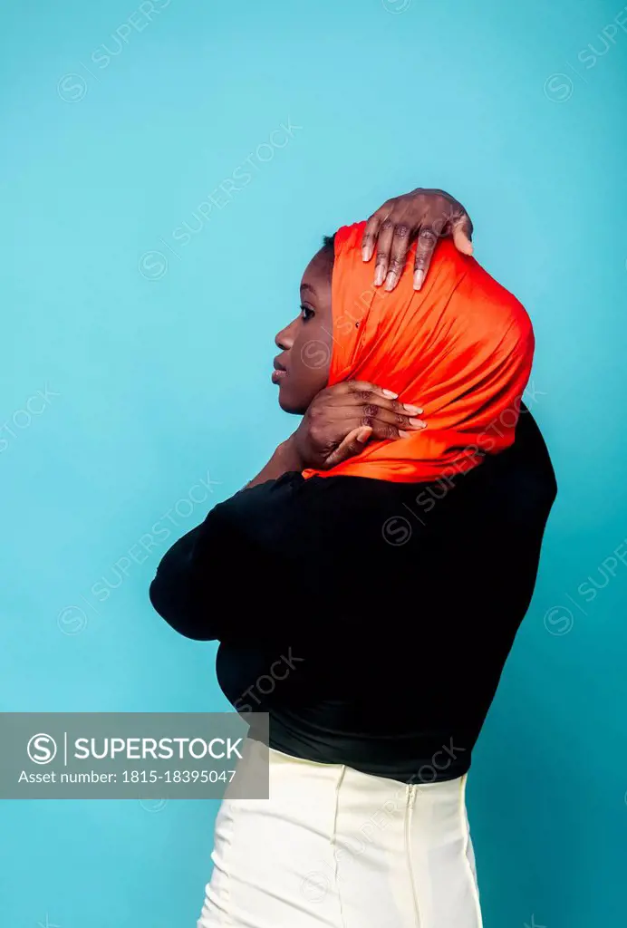 Woman looking away in front of blue background