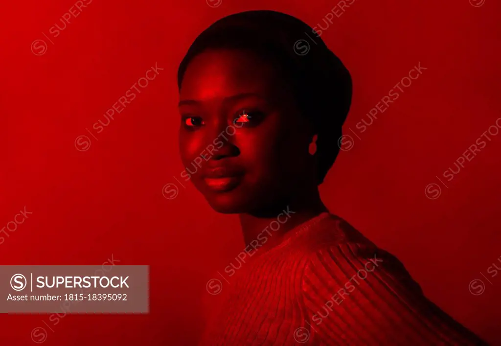 Beautiful young woman against red background