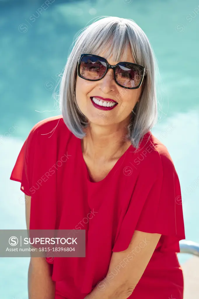 Smiling mature woman wearing sunglasses during sunny day