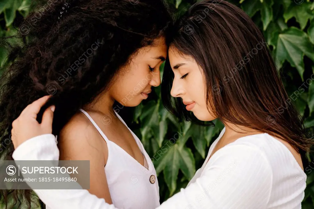 Young women with eyes closed by plants