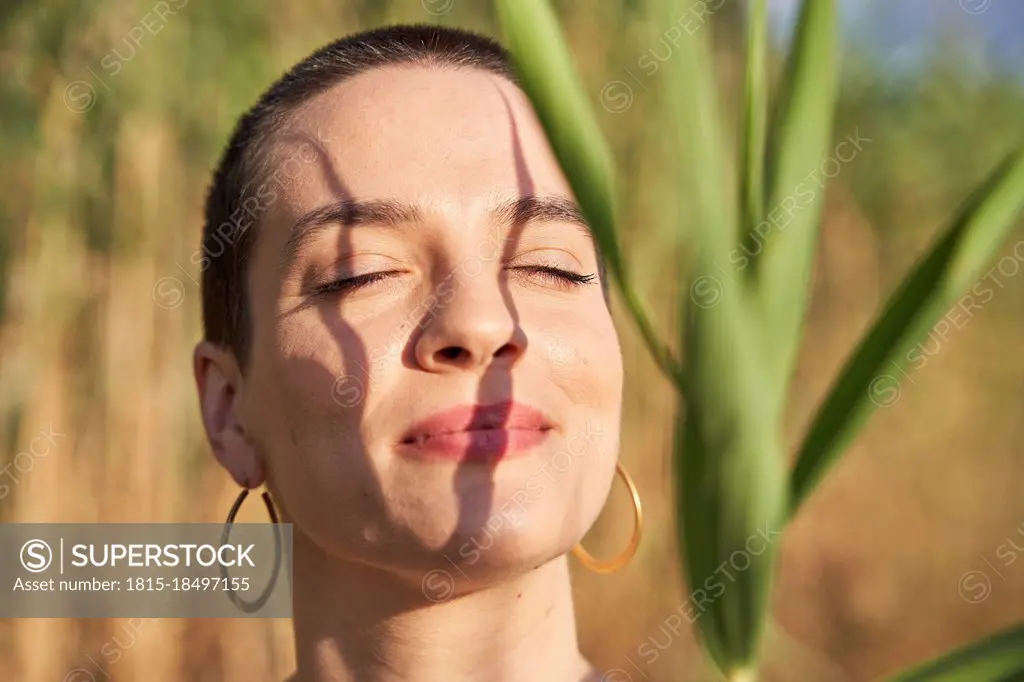Beautiful young woman with eyes closed during sunny day