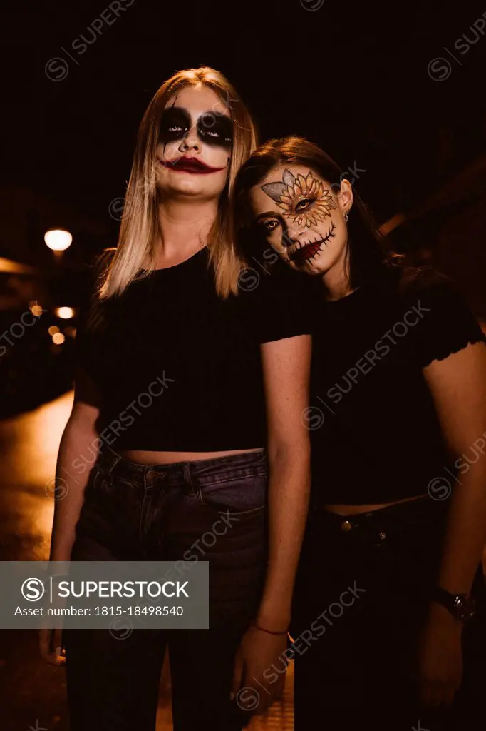Women with ceremonial make-up standing on road during Halloween
