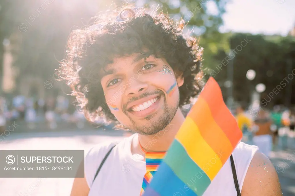 Male activist with rainbow flag in pride event on sunny day