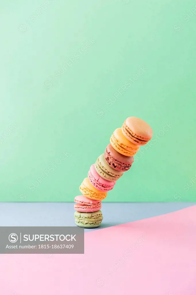Studio shot of stack of pastel colored macaroon cookies falling down