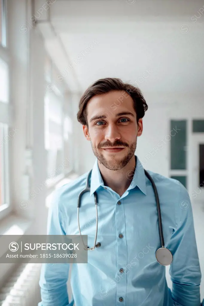 Smiling male doctor with stethoscope in office