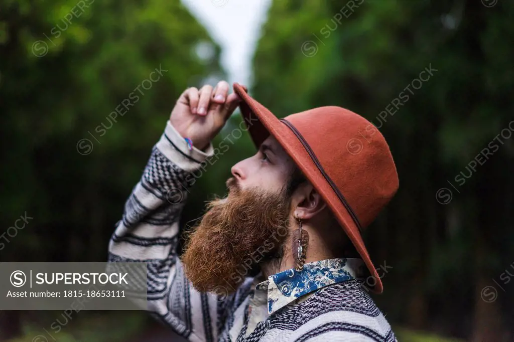Male hipster tourist with brown beard wearing hat