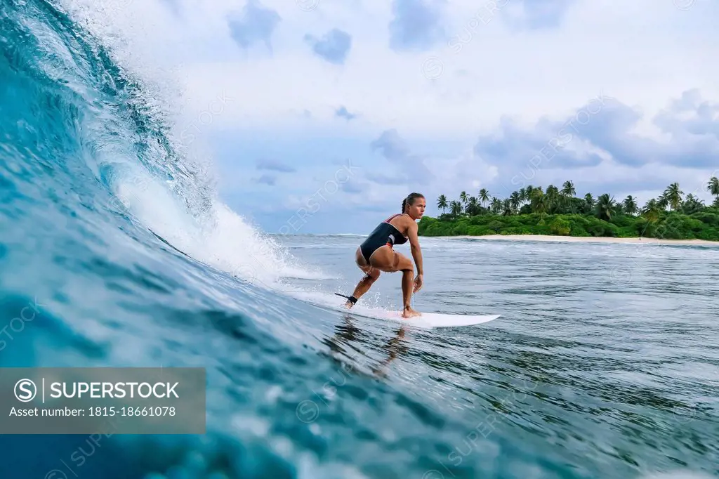 Mid adult woman balancing on surfboard