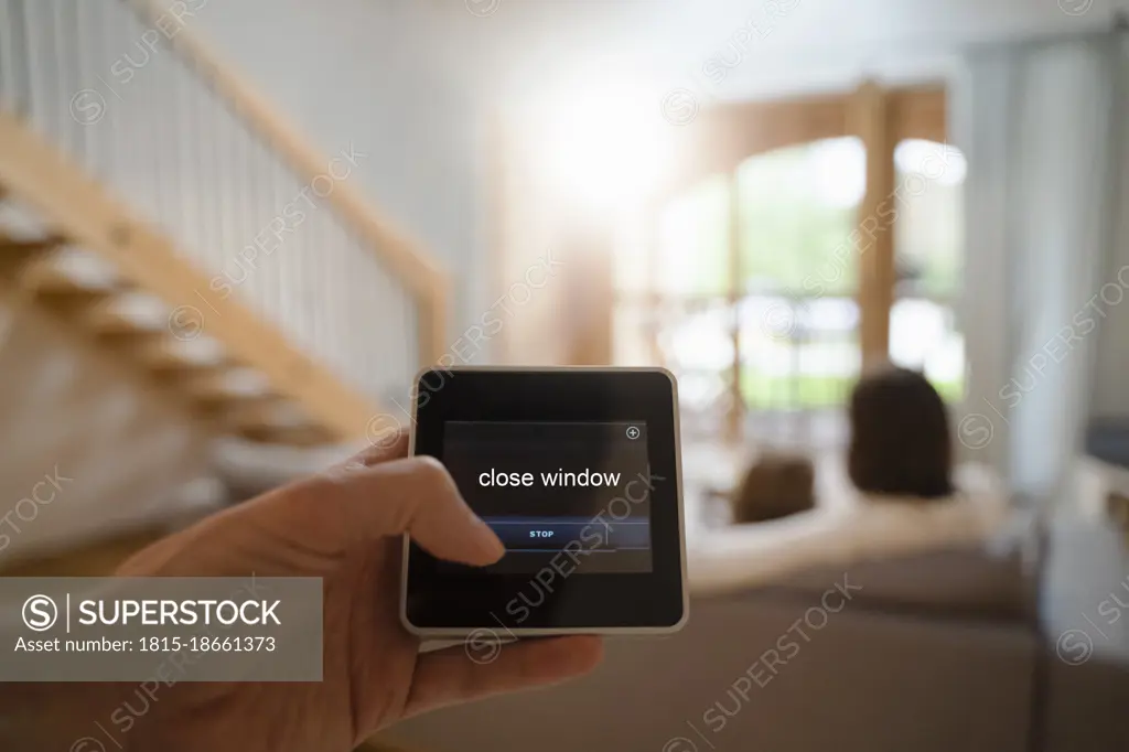 Woman using smart home automation device at home