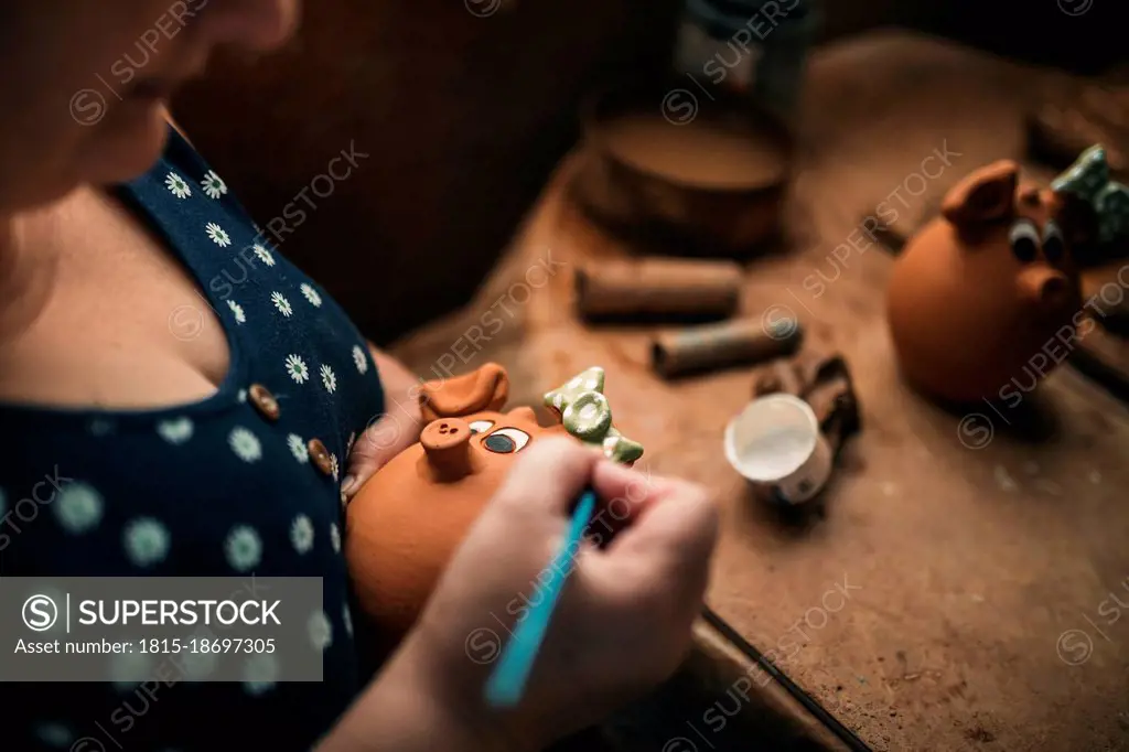 Potter painting on clay in pottery