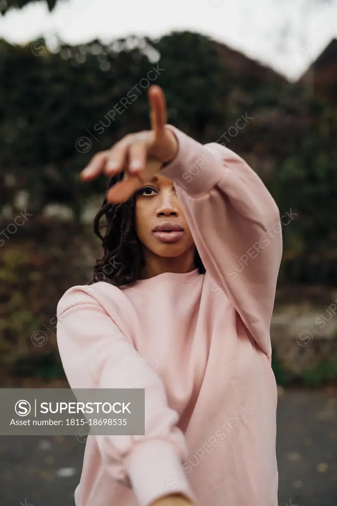 Young woman gesturing on footpath