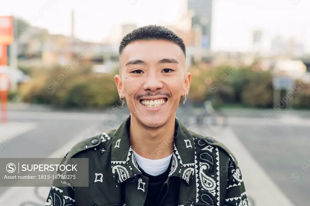 Young man in casual clothing smiling in city