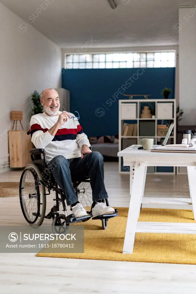 Smiling disabled businessman on wheelchair at home
