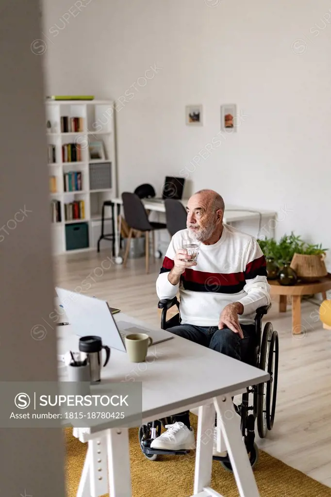 Thoughtful businessman on wheelchair at home office