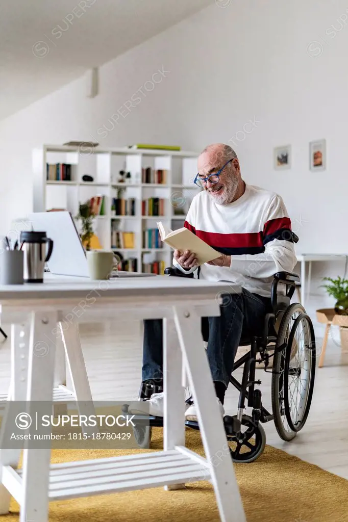 Senior freelancer checking diary on wheelchair at home