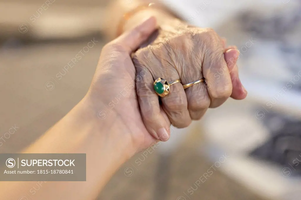 Granddaughter and grandmother holding hands of each other