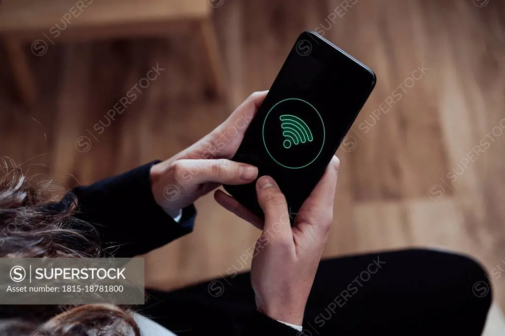 Businesswoman using smart phone with wifi logo on screen