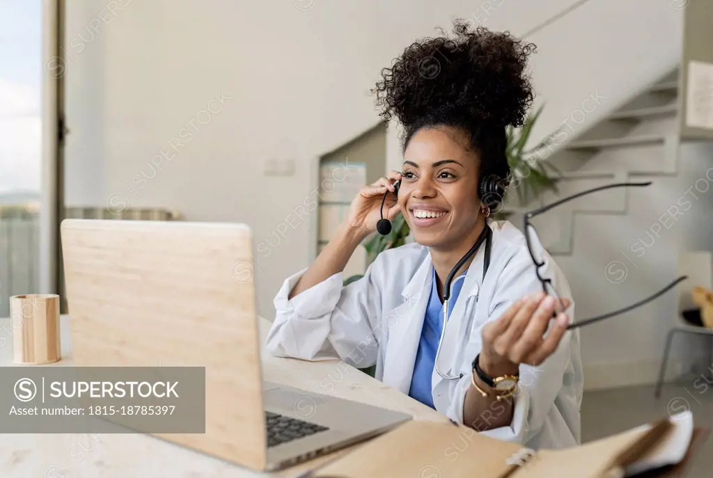 Doctor with talking through headphones at home office