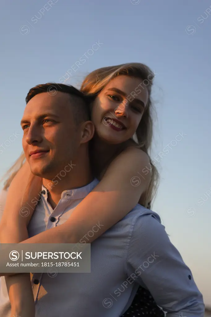 Man piggybacking happy woman