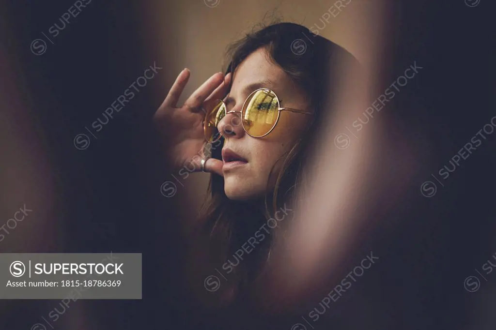 Woman in sunglasses touching head