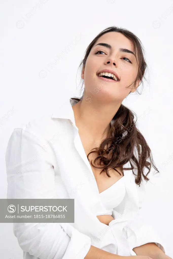Smiling sensuous young woman against white background