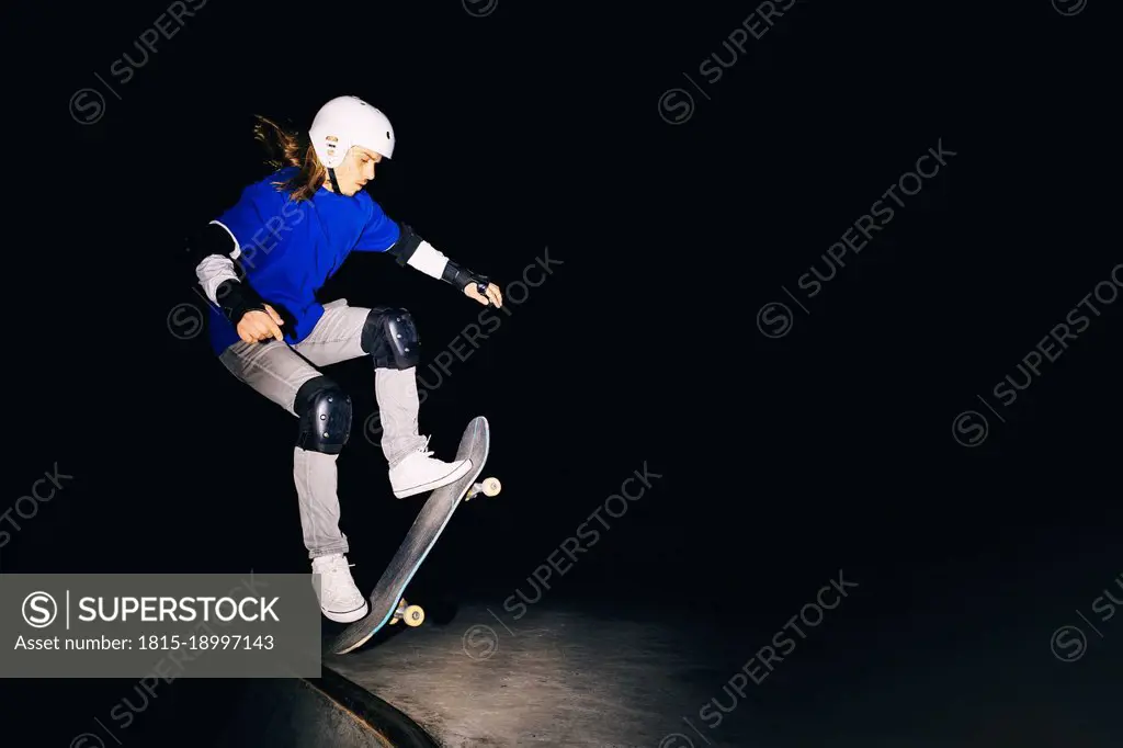 Skateboarder practicing on skateboard at night