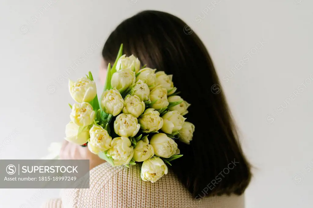 Woman holding bouquet of tulip flowers at home