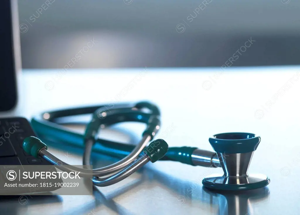 Stethoscope by computer keyboard on desk at hospital