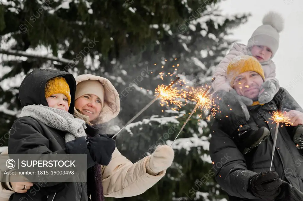 Family with sparklers celebrating in winter