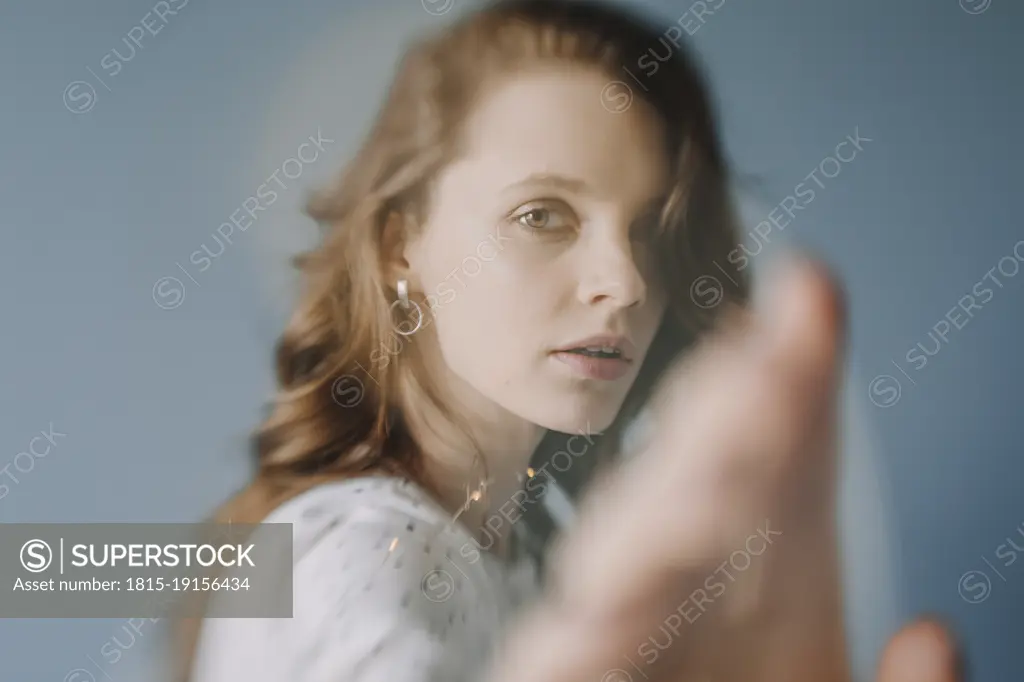 Beautiful woman with brown eyes touching invisible screen