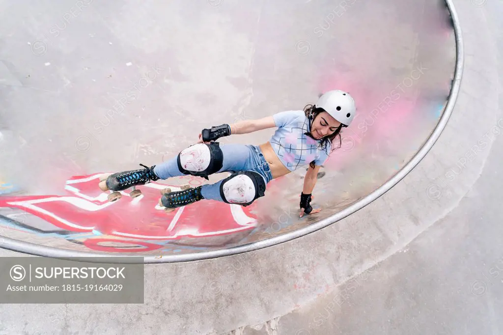 Woman wearing helmet roller skating at park