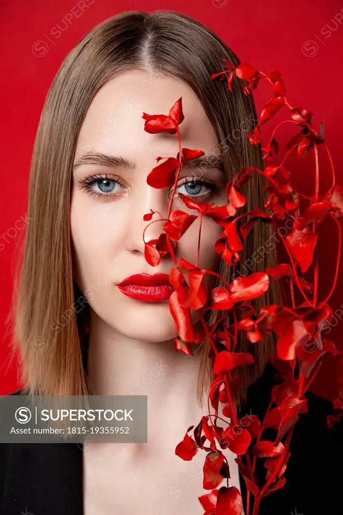 Beautiful young blond woman with red twig
