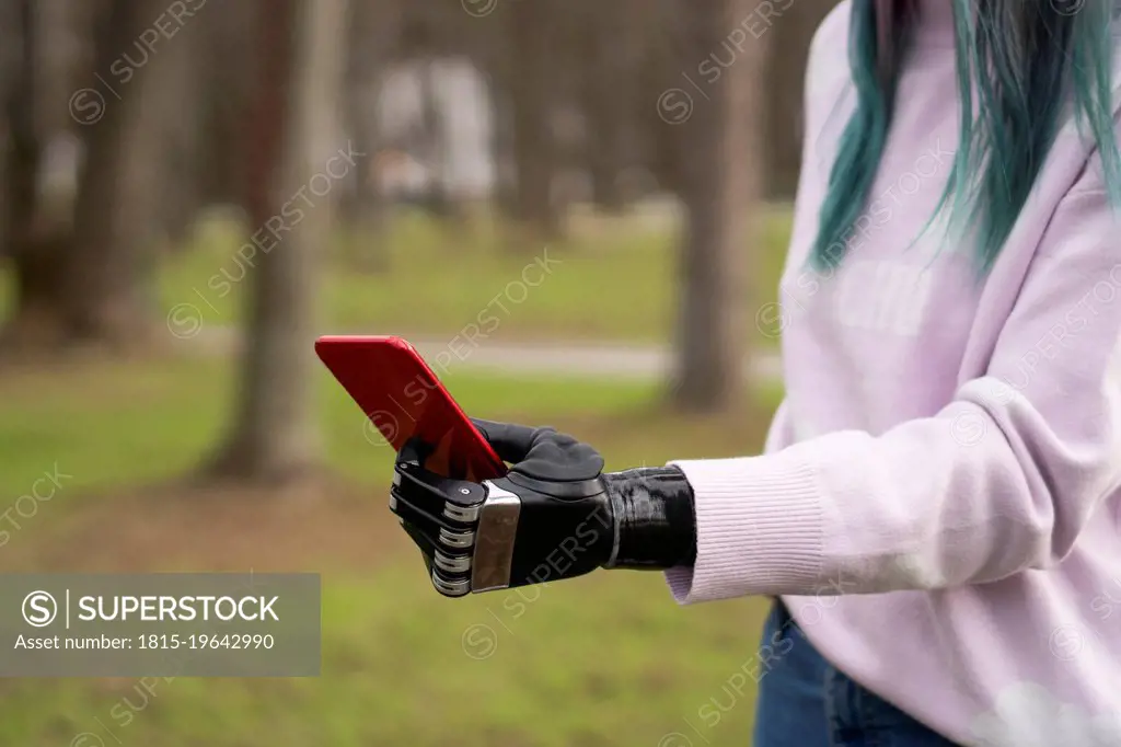 Woman holding smart phone with artificial limb