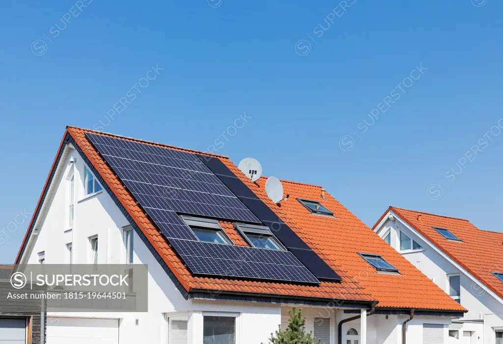 Germany, North Rhine-Westphalia, Solar panels on tiled roofs of modern suburban house