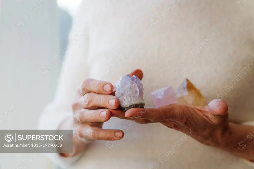 Hands of senior woman holding crystal stones