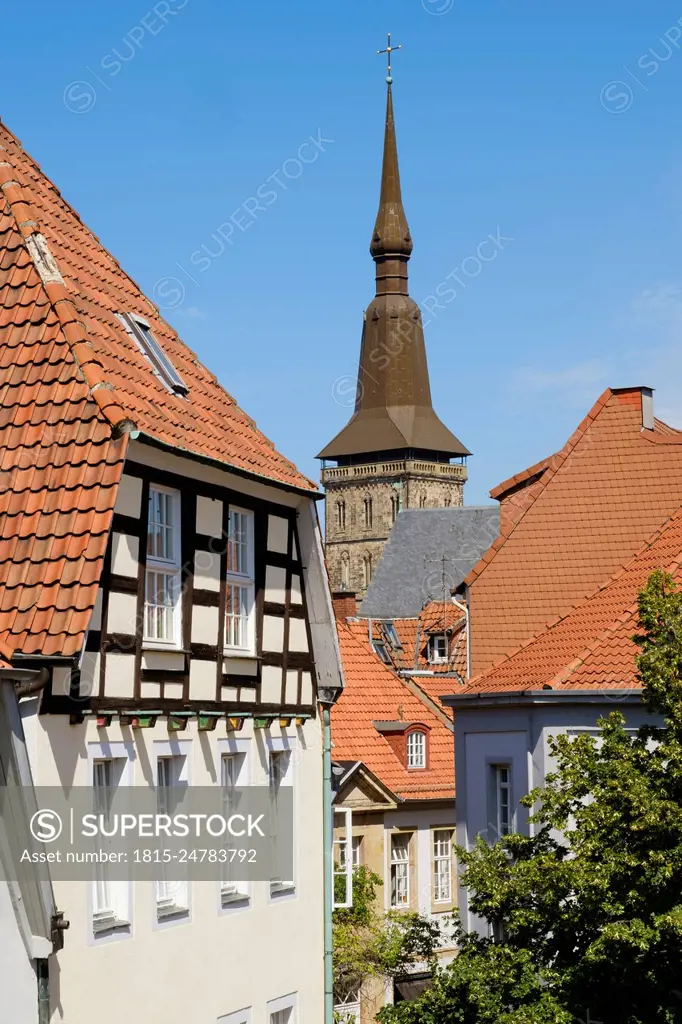 Germany, Lower Saxony, Osnabruck, Old town houses with bell tower of Saint Marys Church in background